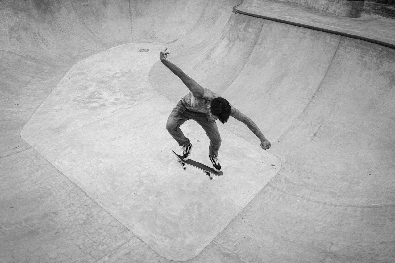 Black and white photo of a skateboarder mid-air in a Bali skatepark, showcasing a daring trick.
